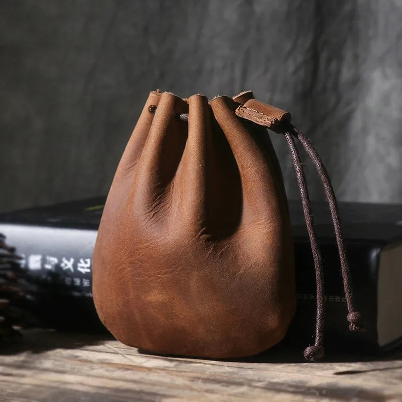 Vintage brown genuine cowhide drawstring bundle wallet laid flat, showing its retro style and stitching details.