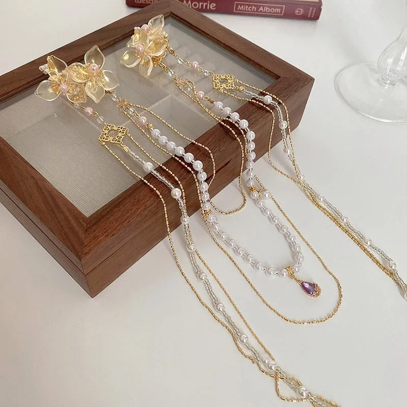 Gold women's hairpin with acrylic pearl, diamond flower decoration, and long dangling tassel.