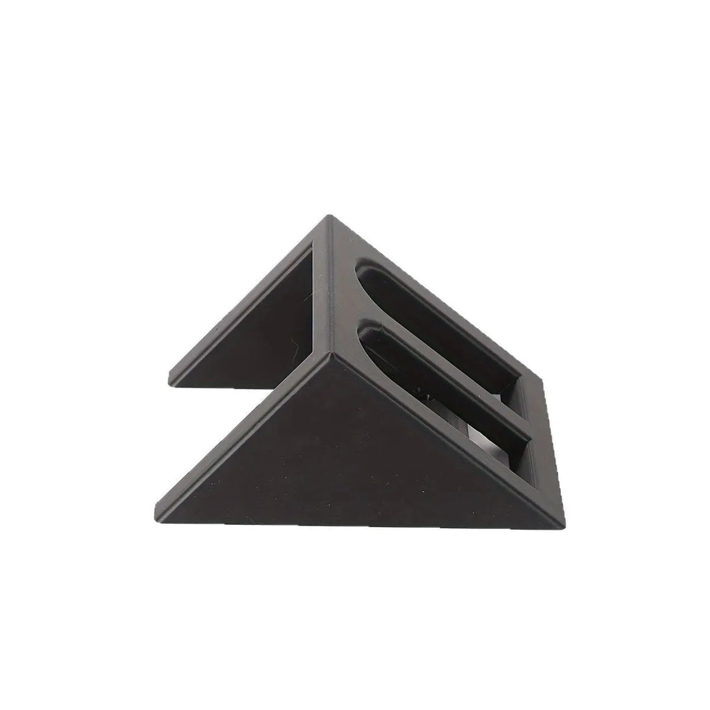 Black punk-style plastic pistol display stand on a surface, showing its compact size and cradle design.