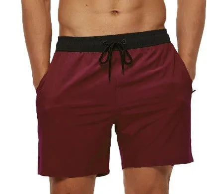 Men's blue drawstring athletic shorts with a zipper pocket and stitching detail on the waistband