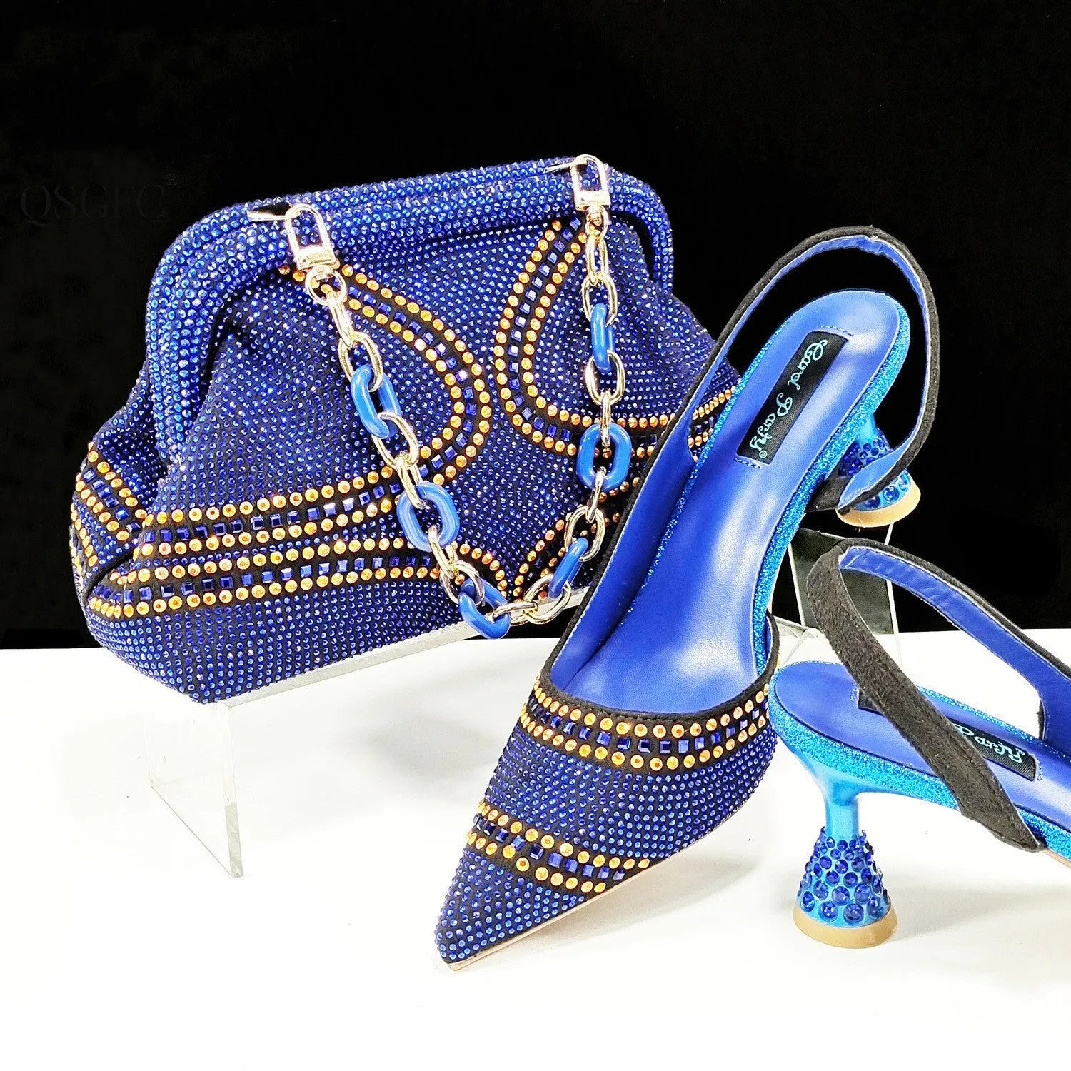 Women's pointed toe high heel shoes with decorative rhinestones and a matching small bag, shown in blue.
