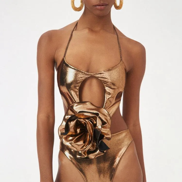 Handmade gold halter neck one-piece swimsuit with hollow out design on a mannequin.