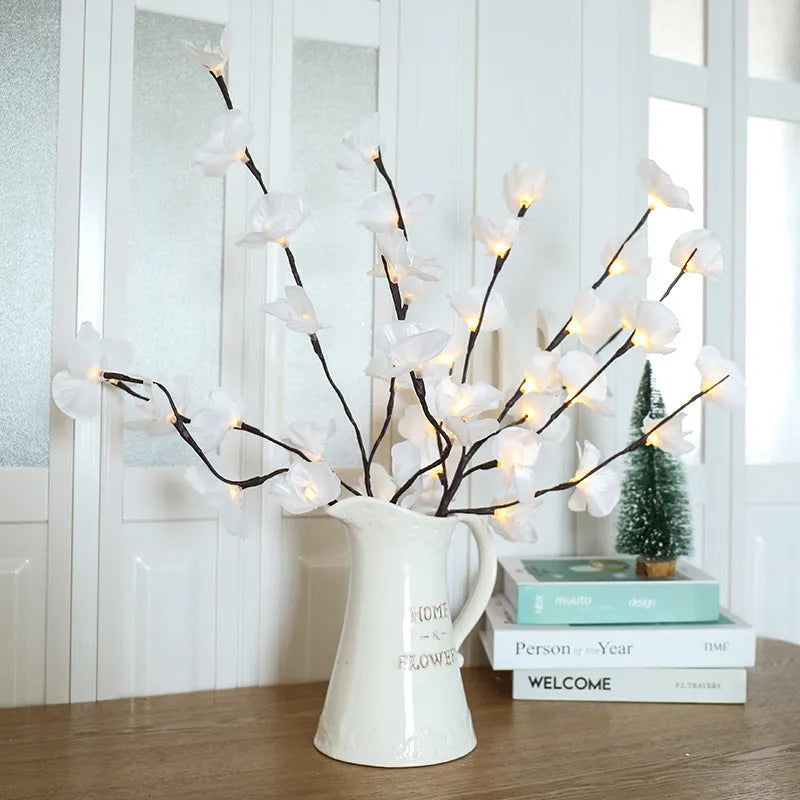 Pink LED phalaenopsis orchid branch decorative light, 65 cm tall, on a table.
