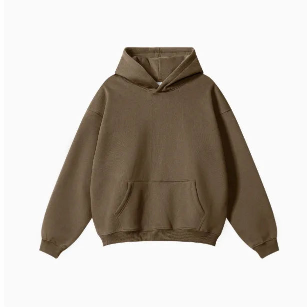 Man wearing a loose-fit cotton terry hooded sweater with drop-shoulder sleeves in a solid colour.