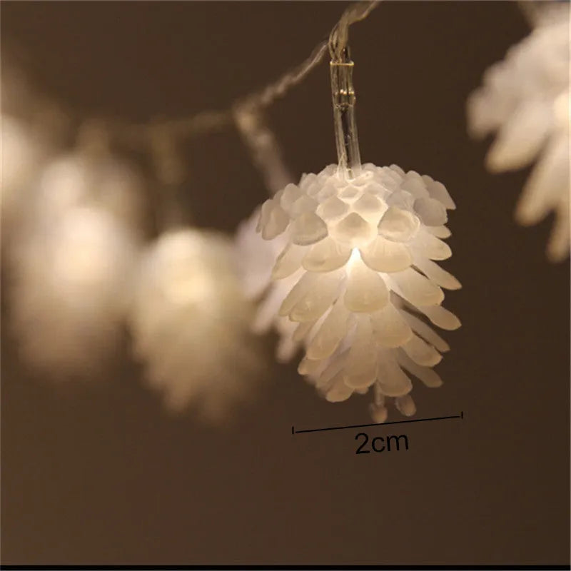 Battery-powered warm white LED pine cone light string with plastic shells, shown in 10 or 20 light options.