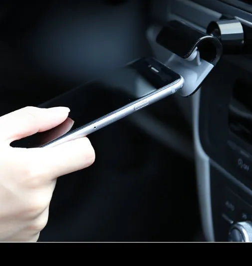 Black gravity car phone holder showing 360-degree rotation on a car dashboard