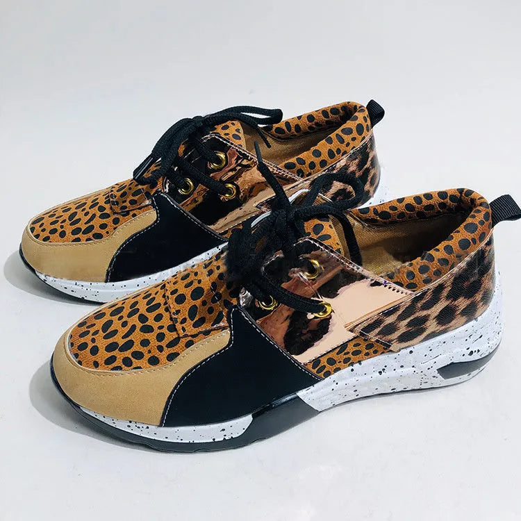 Women's black suede casual sneakers with a wedge heel and round toe on a light background.