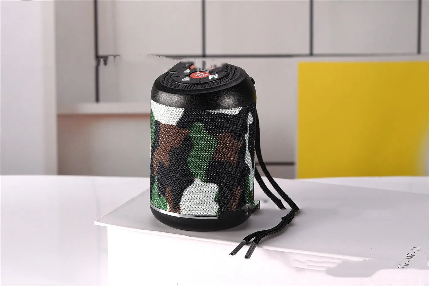 Portable outdoor Bluetooth subwoofer in black with button controls for radio, calls, and playback modes