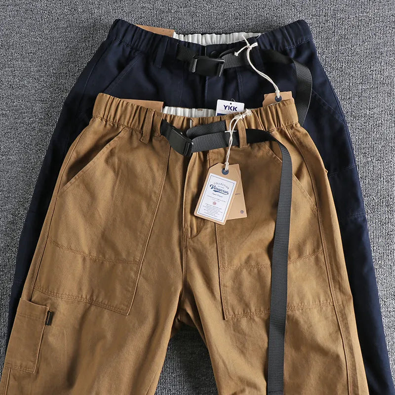 Men's khaki and dark blue cotton casual trousers with a mid-waist fit and zip fly.