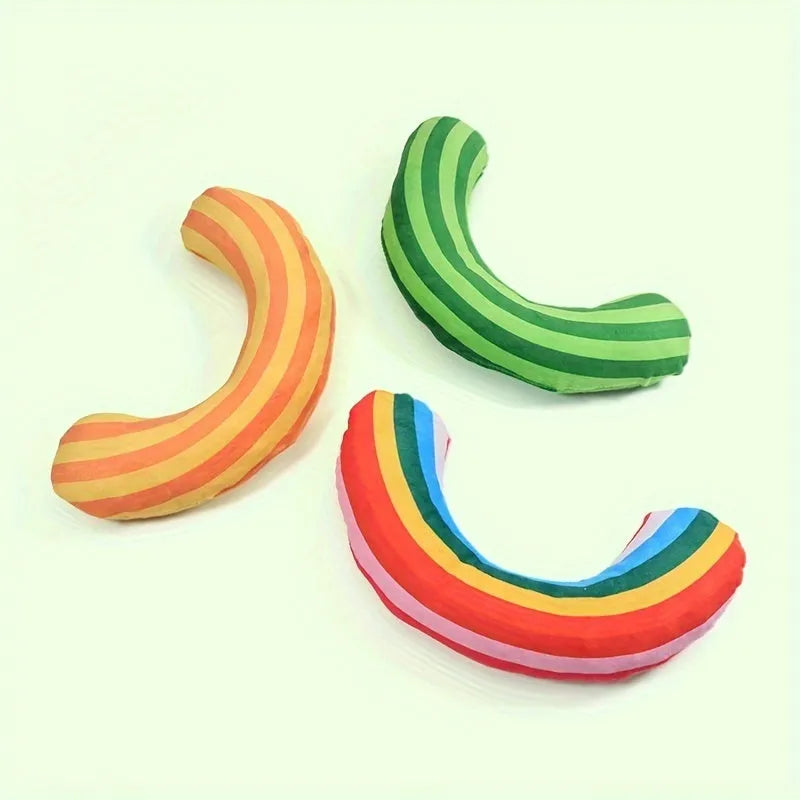 Green cat toy set containing a noise maker with catnip and a small striped pillow on a neutral background