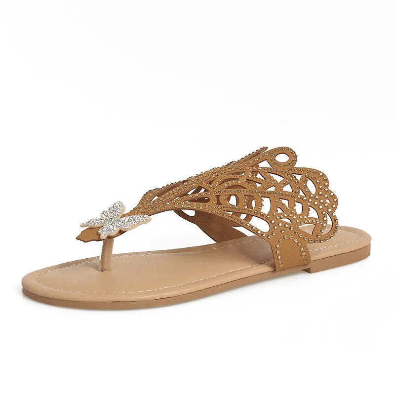 Women's black slip-on sandals with rhinestone decoration on the flip-toe and a flat rubber sole.