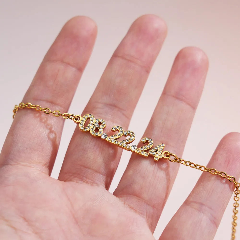 Stainless steel digital bracelet with diamond studded numbers in gold finish.