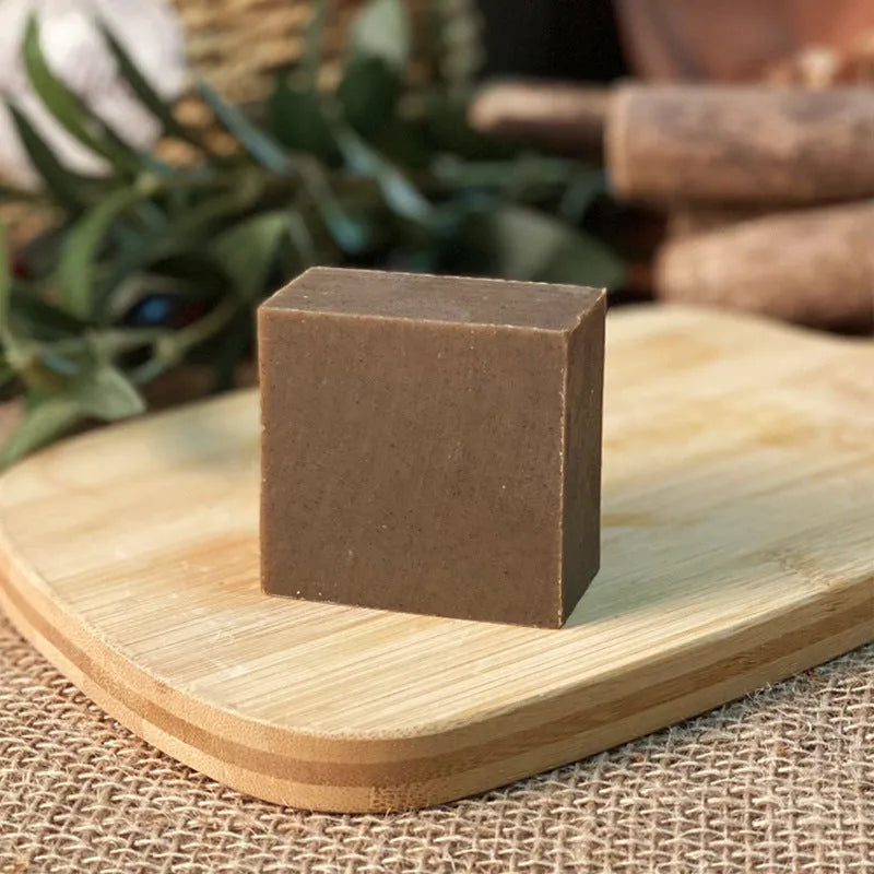 A single 72g round bar of nine herbs cold process shampoo soap on a wooden surface.