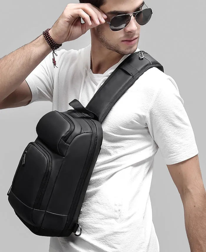 Black PVC outdoor shoulder bag showing internal organisation compartments and air cushion strap