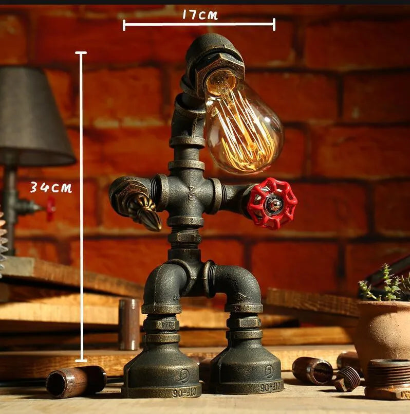 Green bronze vintage robot table lamp with industrial iron pipe design on wooden desk