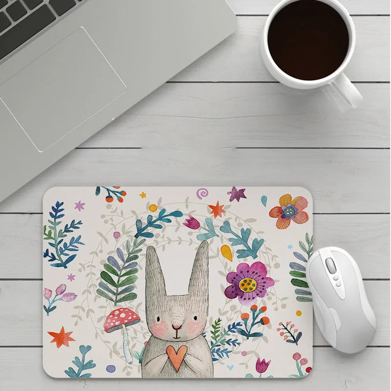 Custom cartoon thickening mouse pad on a desk, showing a colourful design with black stitched edge.