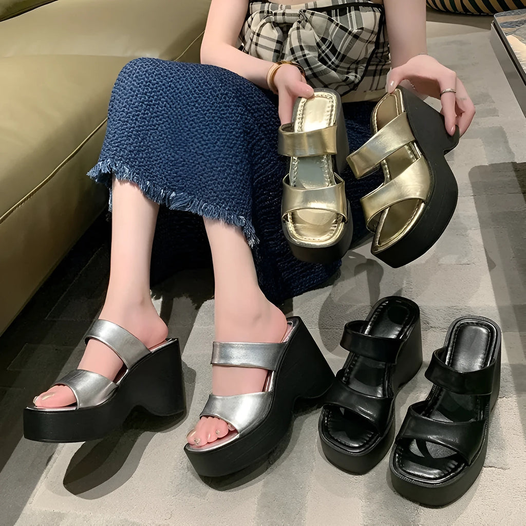 Women's black platform wedge slippers with a square toe design on a white background.