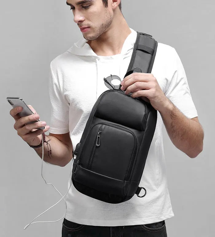 Black PVC outdoor shoulder bag showing internal organisation compartments and air cushion strap