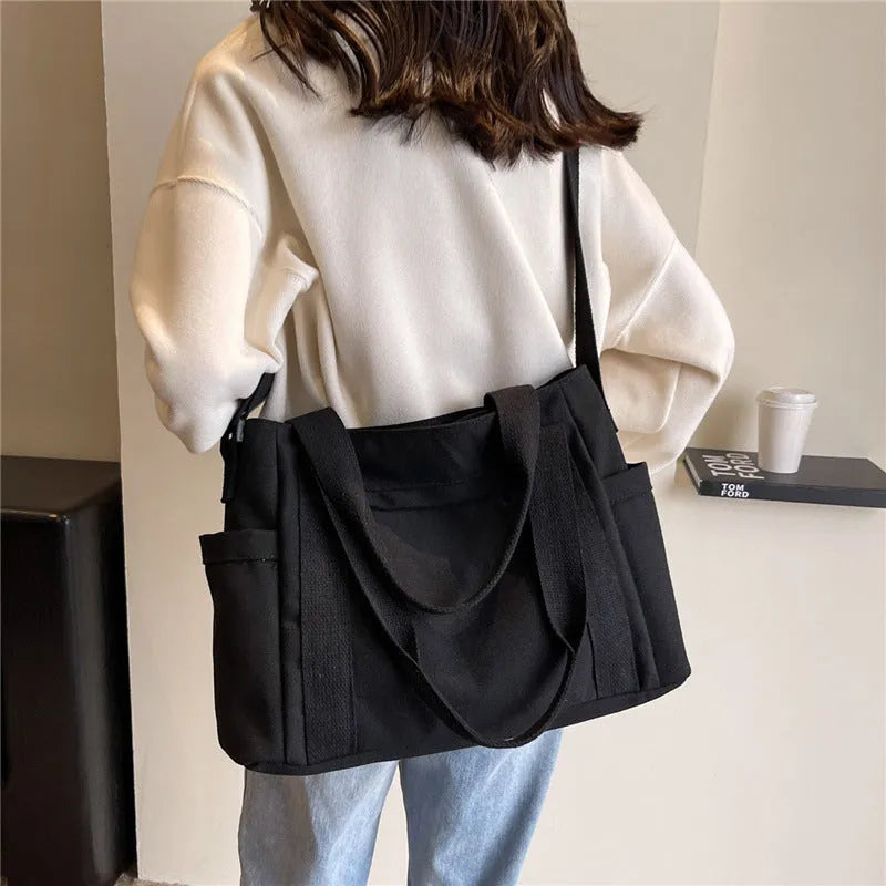 Large polyester canvas shoulder tote bag in solid colour with outer pocket and shoulder strap