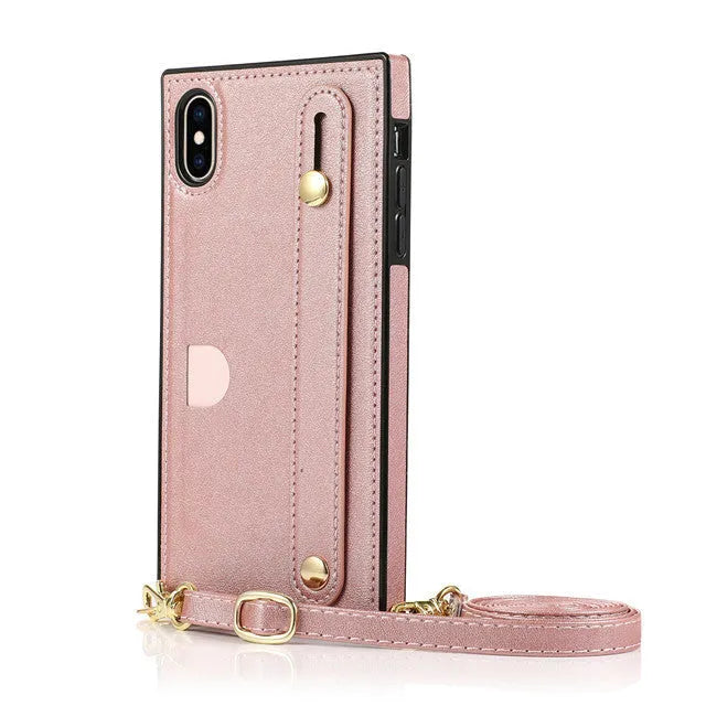Black leather iPhone case with card holder slot and detachable wrist strap on a table
