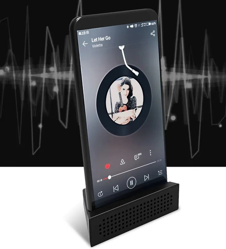 Mini portable phone amplifier bracket for Apple iPhone on a desktop in pink colour.