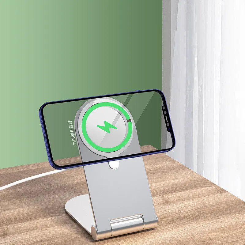 Silver vertical adjustable magnetic phone bracket for iPhone 12 series on a desk.