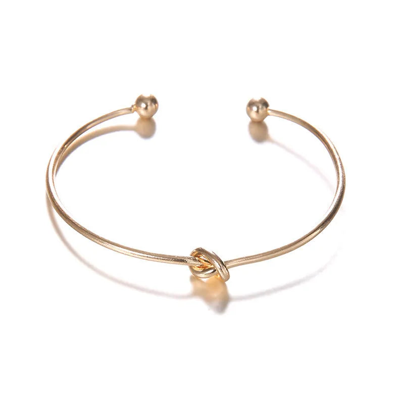 Gold electroplated alloy cuff bracelet with arrow and knot vintage design for women