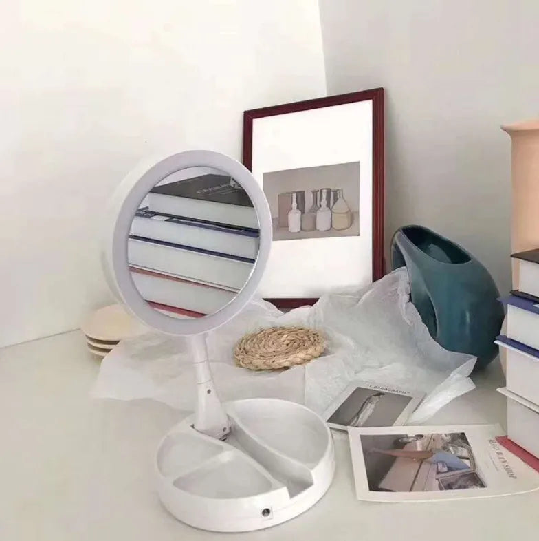 White foldable LED vanity mirror with open storage compartments and USB charging port.