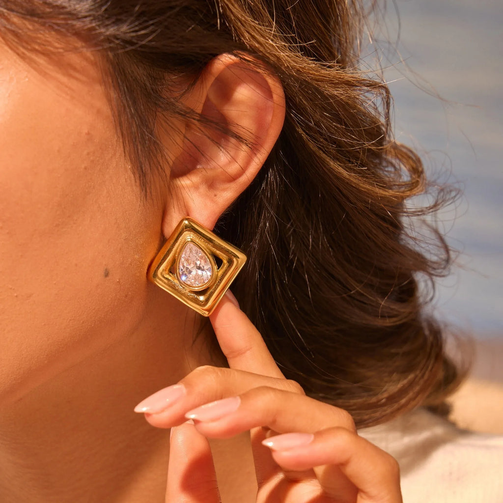 Gold geometric stud earrings for women with inlaid water drop shaped zircon stones.