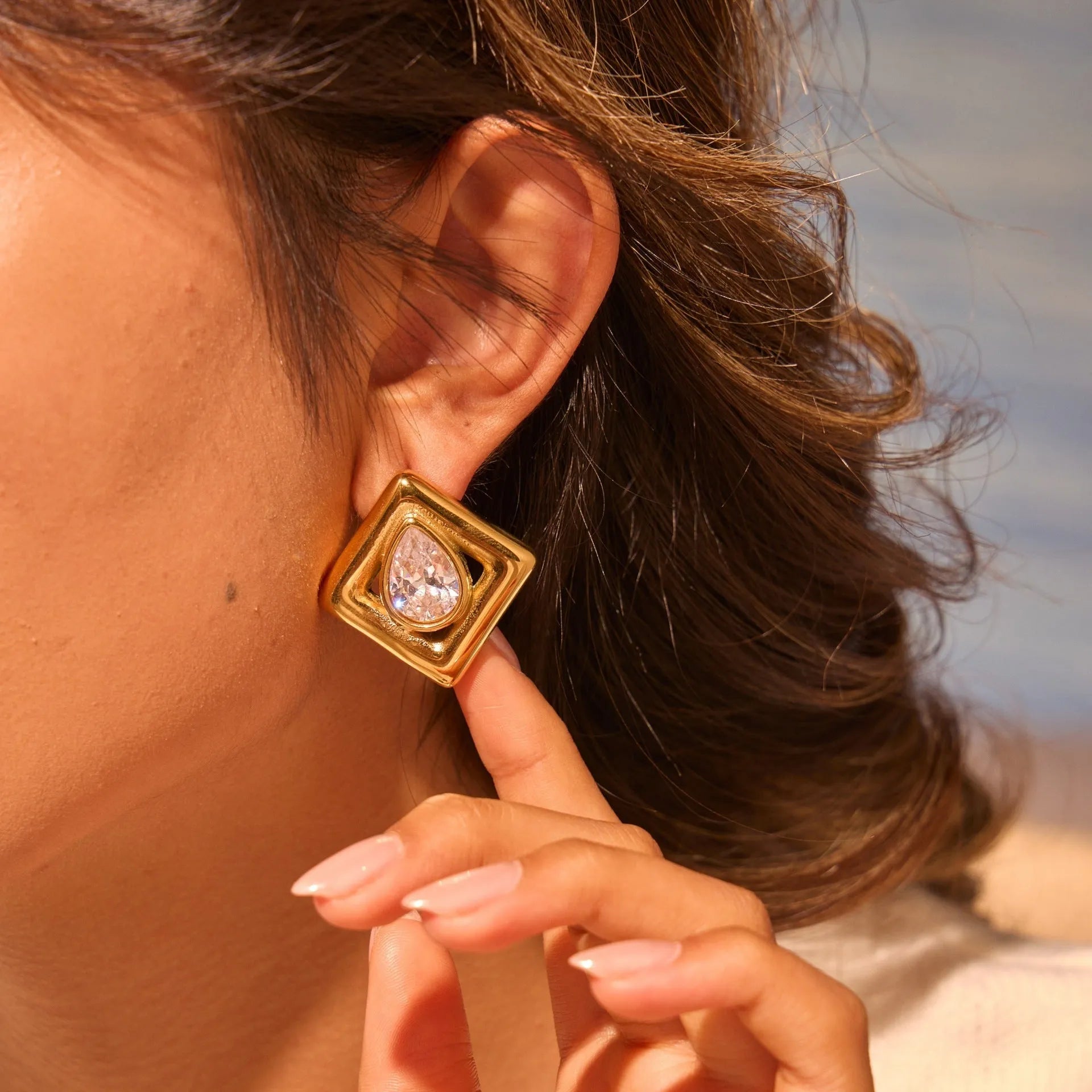 Gold geometric stud earrings for women with inlaid water drop shaped zircon stones.