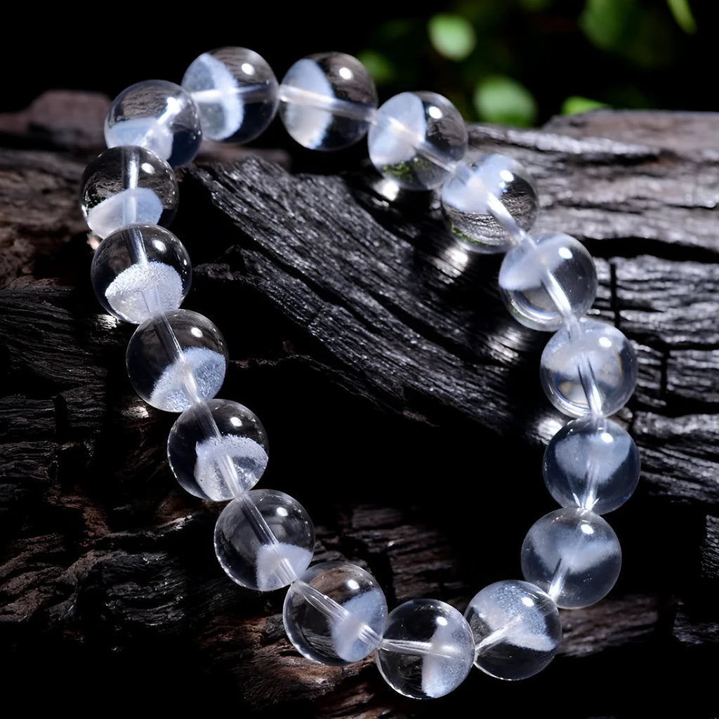 Women's white crystal ghost pyramid bracelet with Ruyi symbol on wrist, showing bead detail.