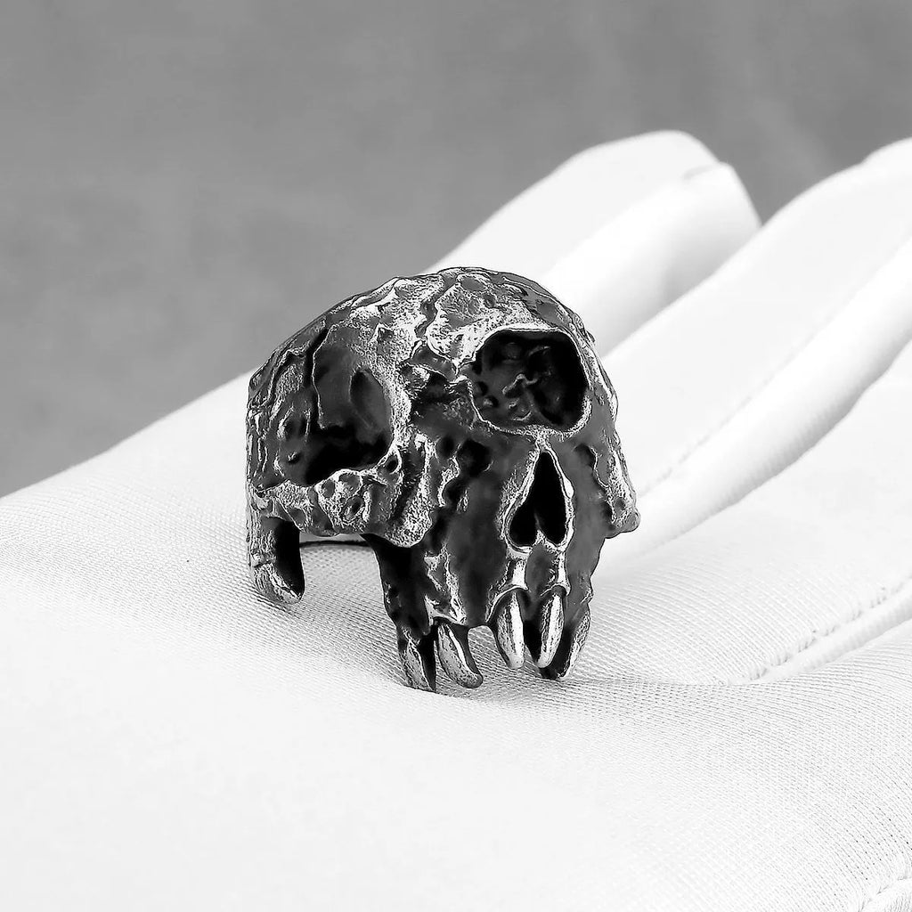 Close-up of a silver-toned alloy ring with a detailed one-eyed skull design on the finger.