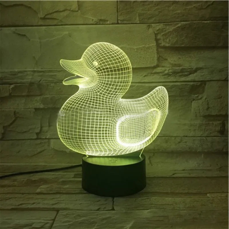 Little Yellow Duck 3D night light showing seven LED colours on a tabletop with remote control.