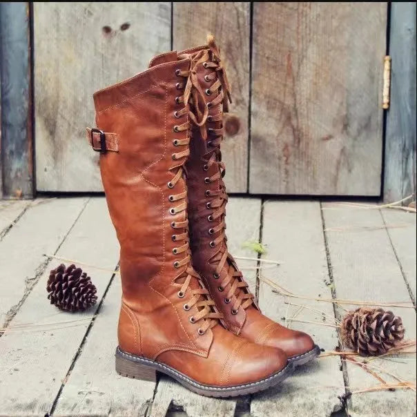 Women's black chunky heel high-leg boots with a round toe and low block heel on a plain background.