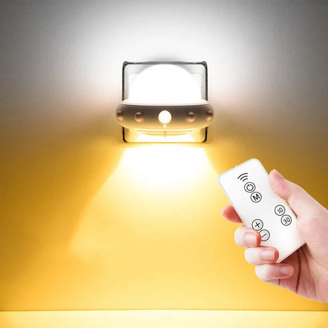 Blue UFO-shaped bedside night light with remote control on a table.