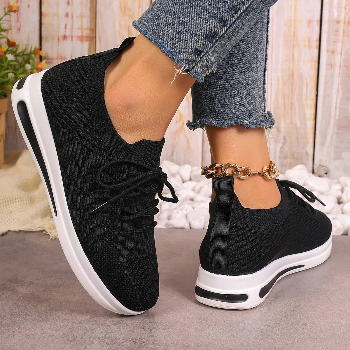 Women's black fly-knit casual sneakers with lace-up front and low-top design on a white background