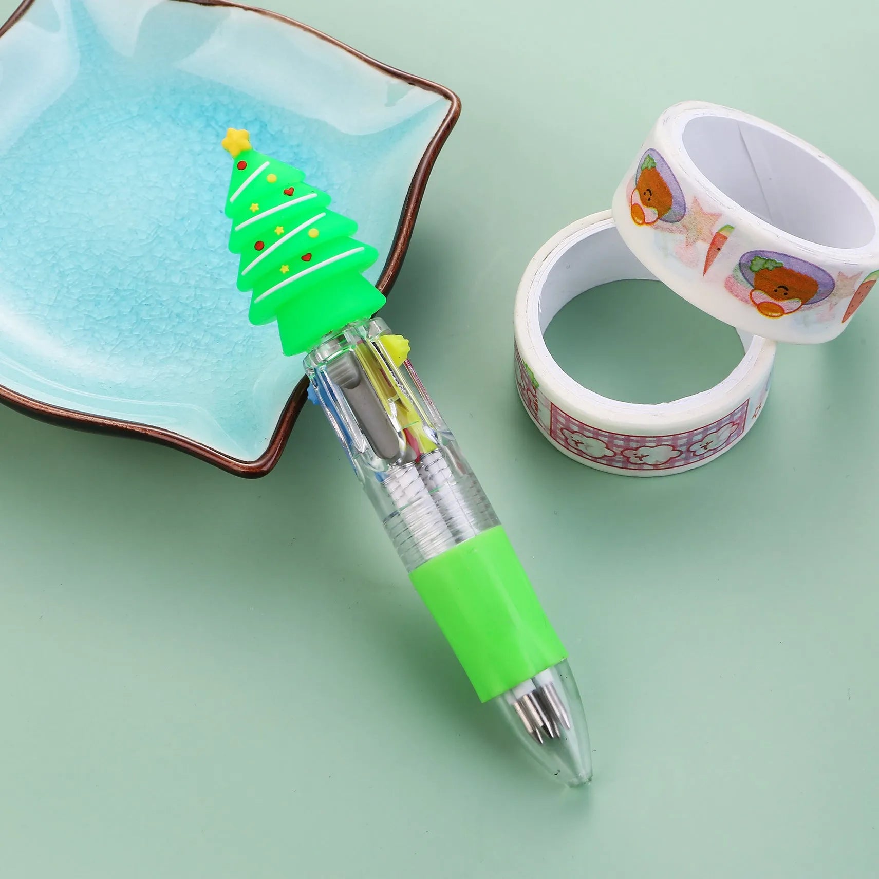 Christmas-themed ballpoint pen with press button, showing designs of snowmen, reindeer, and trees on plastic barrel.