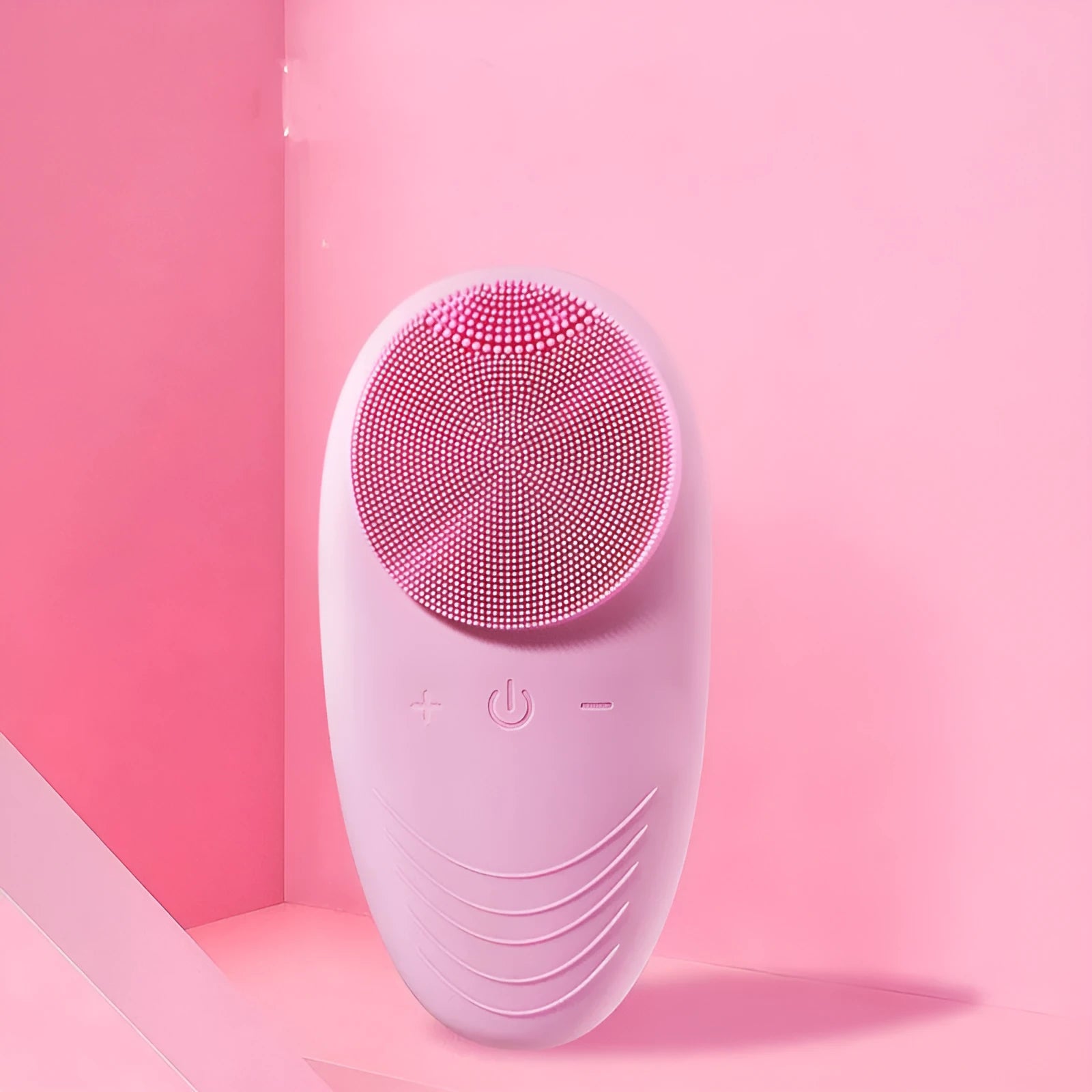 Mini electric facial cleansing brush with food-grade silicone brush head in pink, compact design on white background