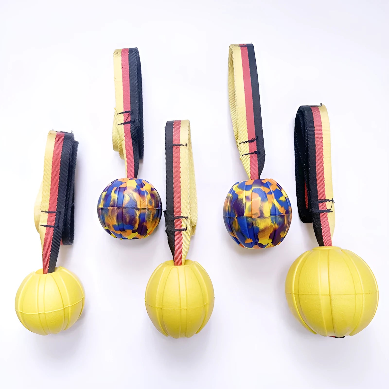 Floating camouflage and yellow EVA dog training balls with string tethers in three different sizes