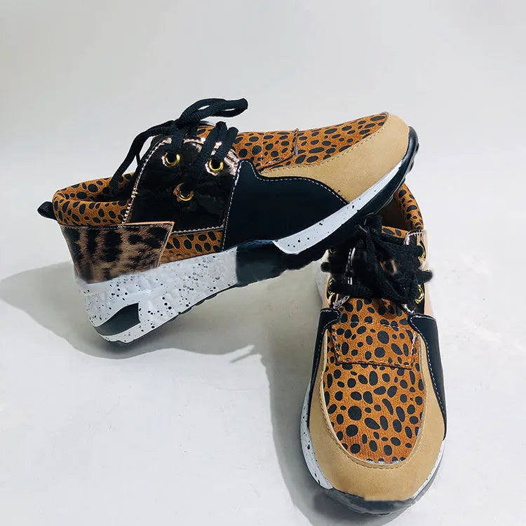 Women's black suede casual sneakers with a wedge heel and round toe on a light background.