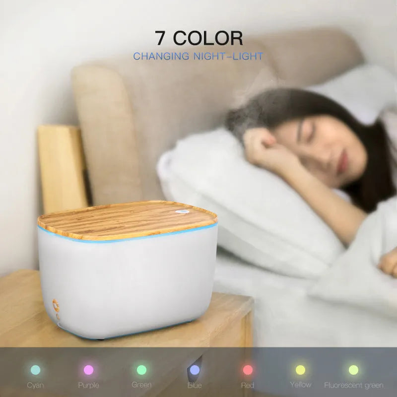 GX-22K white aromatherapy humidifier with night light and water tank on a wooden table.