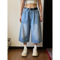 Men's loose fit jeans shorts in blue denim with a straight leg, shown on a model.