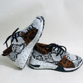 Women's black suede casual sneakers with a wedge heel and round toe on a light background.