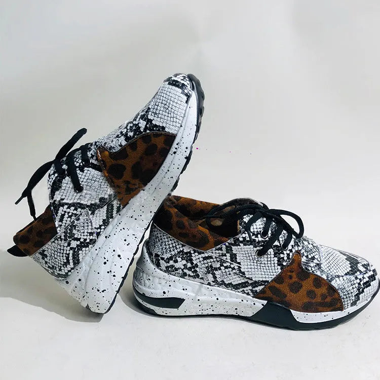 Women's black suede casual sneakers with a wedge heel and round toe on a light background.