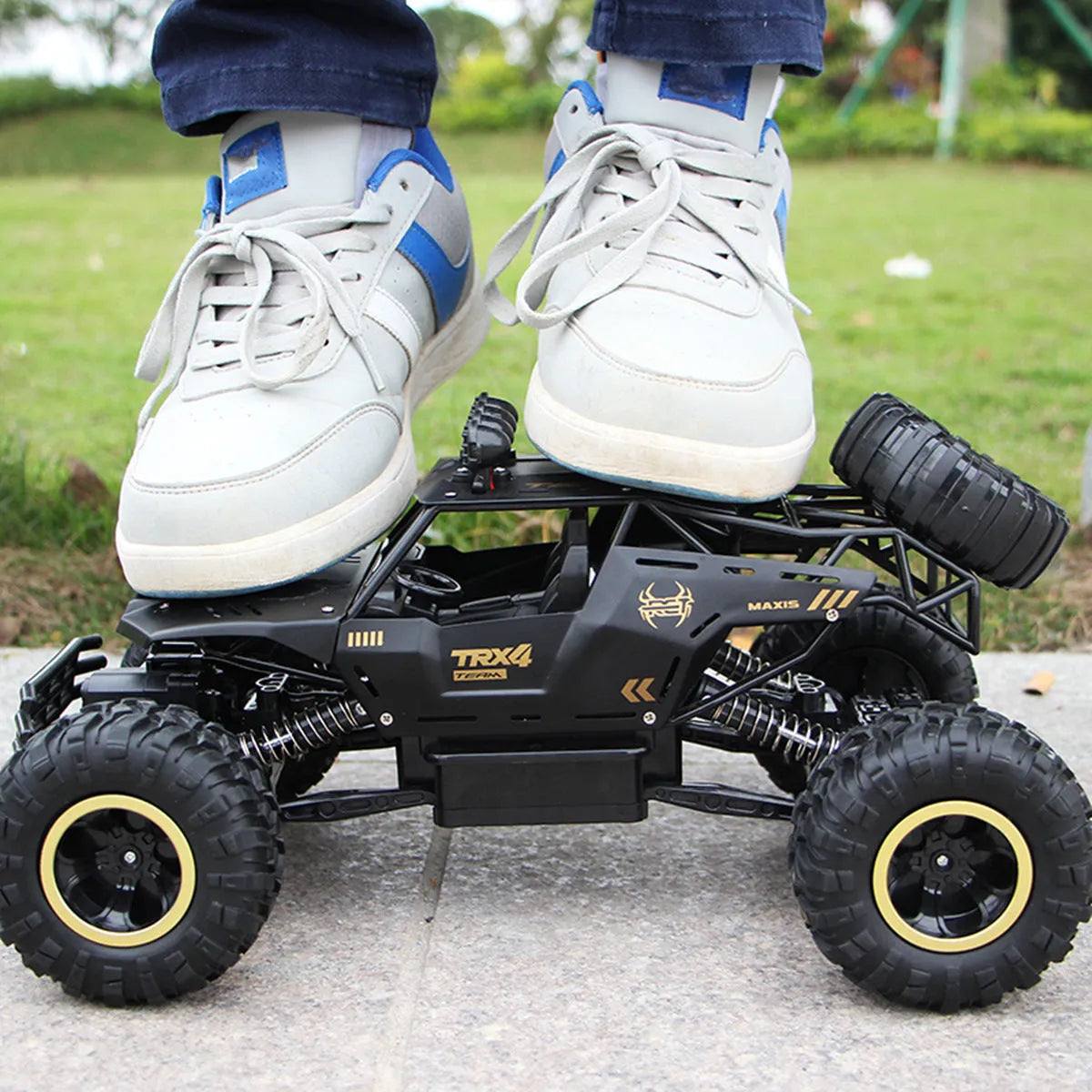 Black and silver remote control climbing cars with 2.4G wireless controller on a rough surface.
