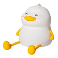 Chubby silicone pat night light on a desk holding a mobile phone, showing its compact size and soft design.