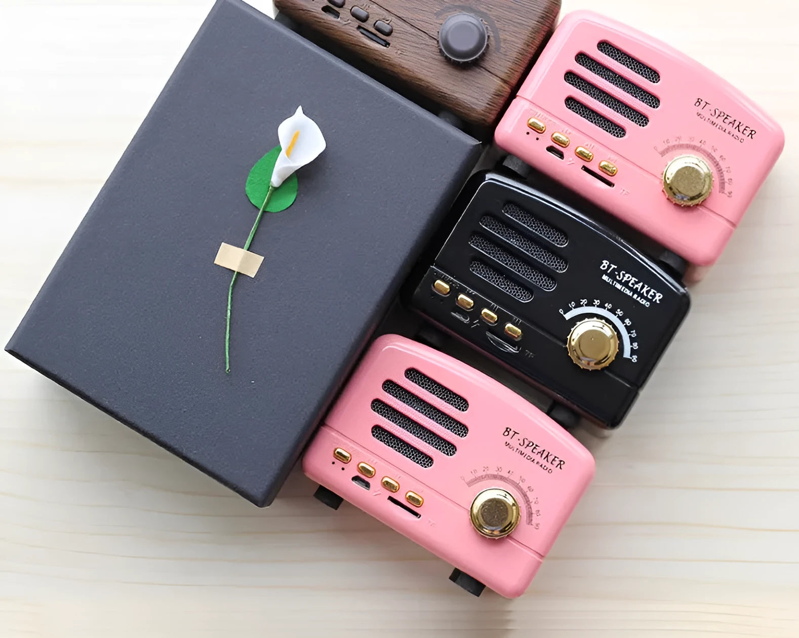 Vintage wood Bluetooth speaker in pink, black, and wood grain colours showing compact 93mm design