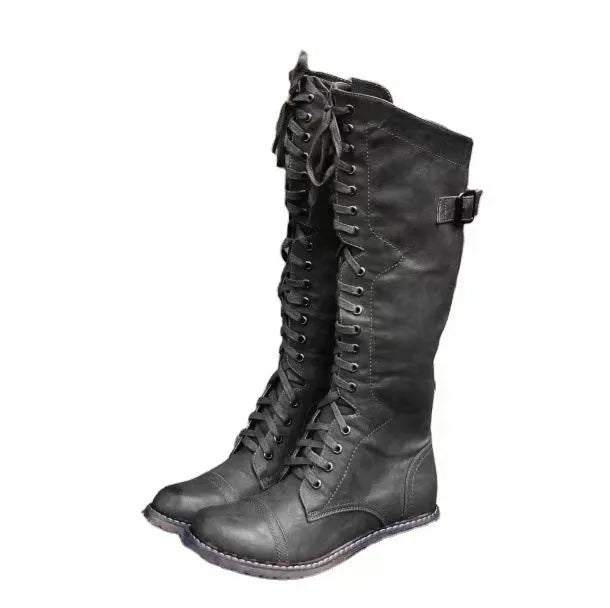Women's black chunky heel high-leg boots with a round toe and low block heel on a plain background.
