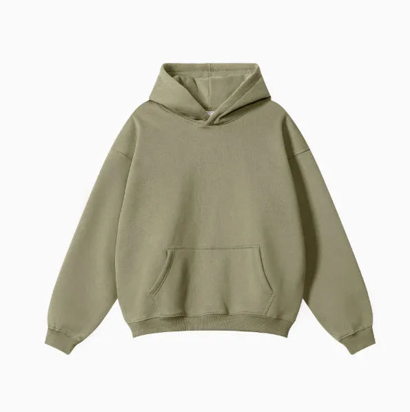 Man wearing a loose-fit cotton terry hooded sweater with drop-shoulder sleeves in a solid colour.