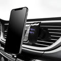 Black car phone holder attached to car air vent with adjustable arms holding mobile device